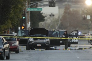 An investigator looks at a Black SUV that was involved in a police shootout with suspects, Thursday, Dec. 3, 2015, in San Bernardino, Calif. A heavily armed man and woman opened fire Wednesday on a holiday banquet, killing multiple people and seriously wounding others in a precision assault, authorities said. Hours later, they died in a shootout with police. (AP Photo/Jae C. Hong)