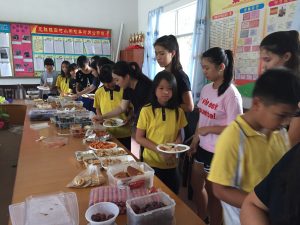 Students of Kaiping school pick up their favorite food with the help of R&S People and Migrant Link girls