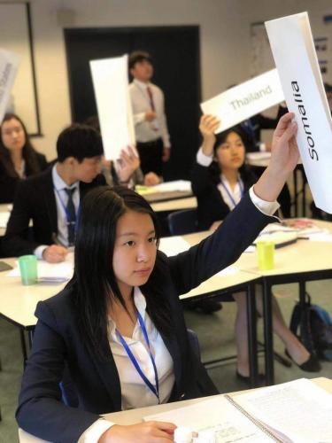 Freshman Shirley Wang raises her placard to vote on a resolution in General Assembly 1. 